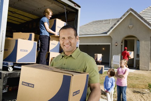 Removal workers handling office furniture carefully